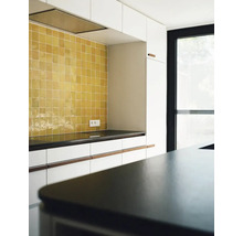 Helle Küche mit gelben Fliesen und dunkler Arbeitsplatte