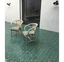 Außenbereich mit zwei Rattansesseln und Bodenfliesen im Fischgrätmuster