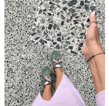 Bodenfliesen mit Terrazzo-Optik und Trägerin mit Turnschuhen