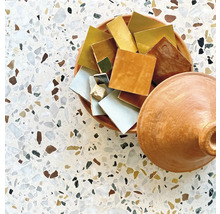 Verschiedenfarbige Keramikfliesen in einer Schale auf einem Mosaiktisch