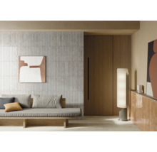 Wohnzimmer mit Fliesenwand, Sofa und dekorativer Beleuchtung für ein modernes Ambiente.