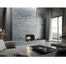 Wohnzimmer mit Kamin, Fliesenwand, Sofa und großem Fenster für ein helles Ambiente