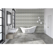 Badezimmer mit freistehender Badewanne, Waschbecken und gemusterten Fliesen