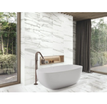 Modernes Badezimmer mit freistehender Badewanne, Armatur und Marmorfliesen.