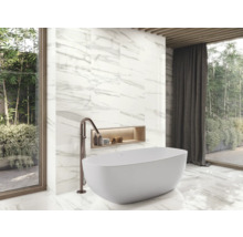 Badezimmer mit Badewanne, Armatur und Wandfliesen in Marmoroptik