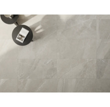 Helle Bodenfliesen mit Marmoroptik verlegt, mit Tisch und Buch.