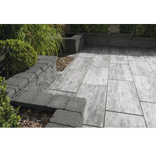 Terrasse mit Pflastersteinen und Steinmauer im Garten