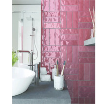 Badezimmer mit Waschbecken, Dusche und Wandfliesen in Ziegeloptik