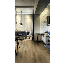 Innenraum mit Holzboden, Esstisch und Sitzgelegenheiten in hellem Design