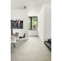 Heller Raum mit Esstisch, Stühlen, Fenster und Kunstwerk