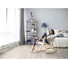 Heller Wohnraum mit Frau im Schaukelstuhl auf Holzboden