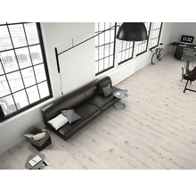 Heller Wohnraum mit Sofa, Tisch und großen Fenstern.