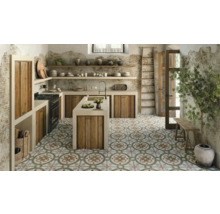 Küchenszene mit Kücheninsel, Holzschränken, Regalen und dekorativem Bodenmuster.