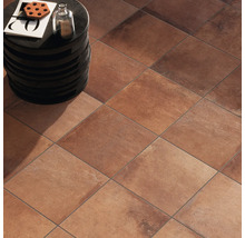 Bodenansicht mit quadratischen Terrakottafliesen und einem kleinen Beistelltisch