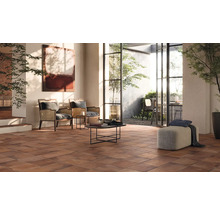 Helles Wohnzimmer mit Terrakottafliesen, Sesseln und Blick in den Garten