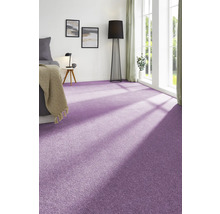 Ein Schlafzimmer mit lila Teppichboden, einem Bett, einem Beistelltisch und einer Stehlampe.