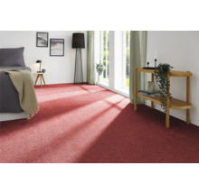 Raumansicht mit rotem Teppichboden, Bett, Beistelltisch und Dekoration