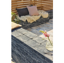 Terrassengestaltung mit Steinmauer, Kissen und Dekoration