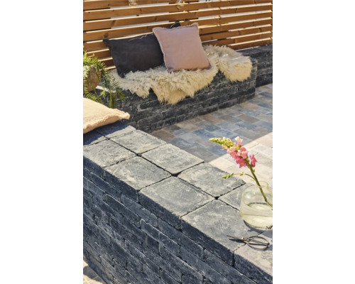 Terrassengestaltung mit Steinmauer, Kissen und Dekoration