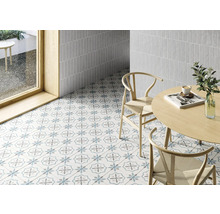 Heller Raum mit Boden- und Wandfliesen, Tisch und Stühlen.