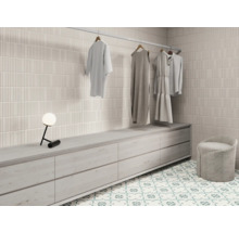 Helles Ankleidezimmer mit Fliesenwand, Kommode, Hocker und Kleiderstange mit Kleidung