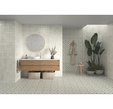 Helles Badezimmer mit quadratischen Wandfliesen, Waschtisch mit Spiegel und gemusterten Bodenfliesen