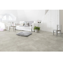 Heller Wohnraum mit Sofa, Tisch, Kissen und Bodenbelag