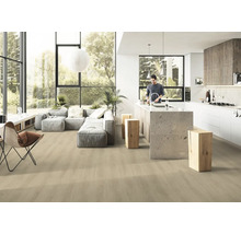 Heller, offener Wohnraum mit Holzboden, grauer Couch und Kücheninsel