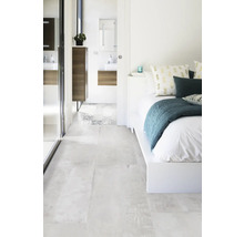 Helles Schlafzimmer mit Bad und passenden Bodenfliesen.