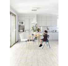 Heller Küchenraum mit Esstisch, Stühlen und einem Mädchen beim Essen.