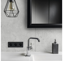 Badezimmer mit Waschbecken, Armatur, Seifenspender, Spiegel, Steckdose und Lampe