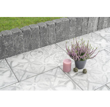 Gestaltungsidee für Terrasse mit Pflastersteinen, Rasenkantensteinen, Heidekraut und Kerze