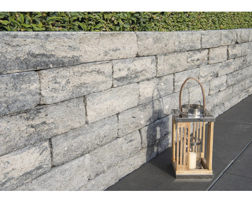 Graue Gartenmauer mit dekorativer Laterne