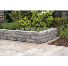 Gartenmauer aus Steinen mit Bepflanzung und Bodenplatten