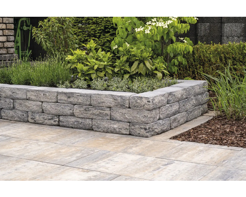 Gartenmauer aus Steinen mit Bepflanzung und Bodenplatten