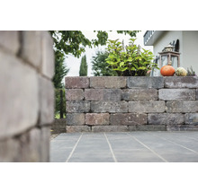 Gartenmauer aus Stein mit Bepflanzung und Dekoration