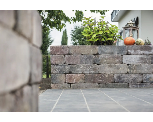 Gartenmauer aus Stein mit Bepflanzung und Dekoration