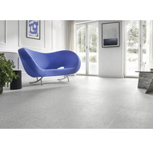 Heller Raum mit Bodenfliesen, Sofa und Fenstern