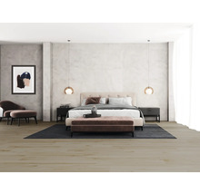 Schlafzimmer mit Doppelbett, Nachttischen, Teppich und Sitzmöbeln