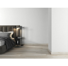 Helles Schlafzimmer mit Doppelbett, Nachttischlampe und Holzboden