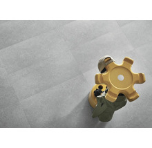 Verlegte Bodenfliesen mit Arbeitshocker im Raum.