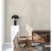 Wohnzimmer mit Mustertapete, Tischleuchte, Holzkommode und Holzstühlen