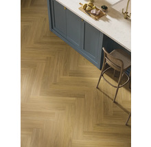 Verlegung von Holzimitatfliesen im Fischgrätmuster in einem Küchenbereich.