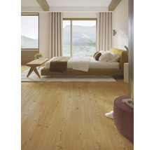 Helles Schlafzimmer mit Bett, Holzfußboden und Ausblick auf die Berge.