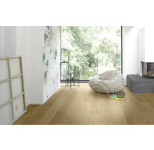 Heller Holzboden in einem Wohnzimmer mit Sessel, Lampe und Kamin