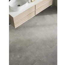 Badezimmer mit Waschbecken auf Waschtisch und grauen Bodenfliesen.