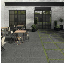 Außenbereich mit Terrassenplatten, Tischen, Stühlen und Pflanzen