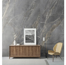 Wohnzimmer mit grauer Marmorwand, Holzkommode und Sessel