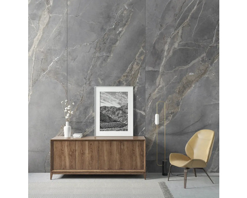 Wohnzimmer mit grauer Marmorwand, Holzkommode und Sessel