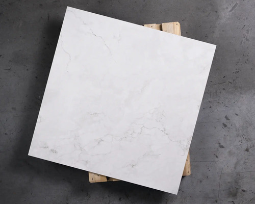 Quadratische, weiße Bodenfliese mit Marmorierung auf Holzpalette